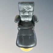 A Scandinavian swivel relaxer armchair with footstool in black leather