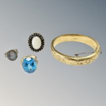 A rolled gold bangle together with a gold plated dress ring set a blue stone and two further dress