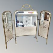 A brass mirrored fire screen