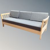 A Scandinavian wood framed day bed in grey fabric, 215cm long by 81cm deep by 82cm high.