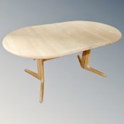 An oval Mobler extending dining table fitted a leaf and four similar rail back chairs