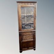 A Jaycee Oak corner cabinet with leaded glass door