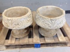 A pair of concrete garden planters on stands