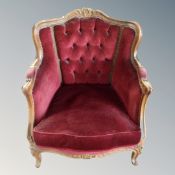 A baroque style carved beech framed armchair in red buttoned dralon