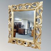 A decorative gilt period- style wall mirror in swept frame