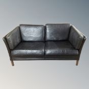 A Scandinavian black leather two seater settee