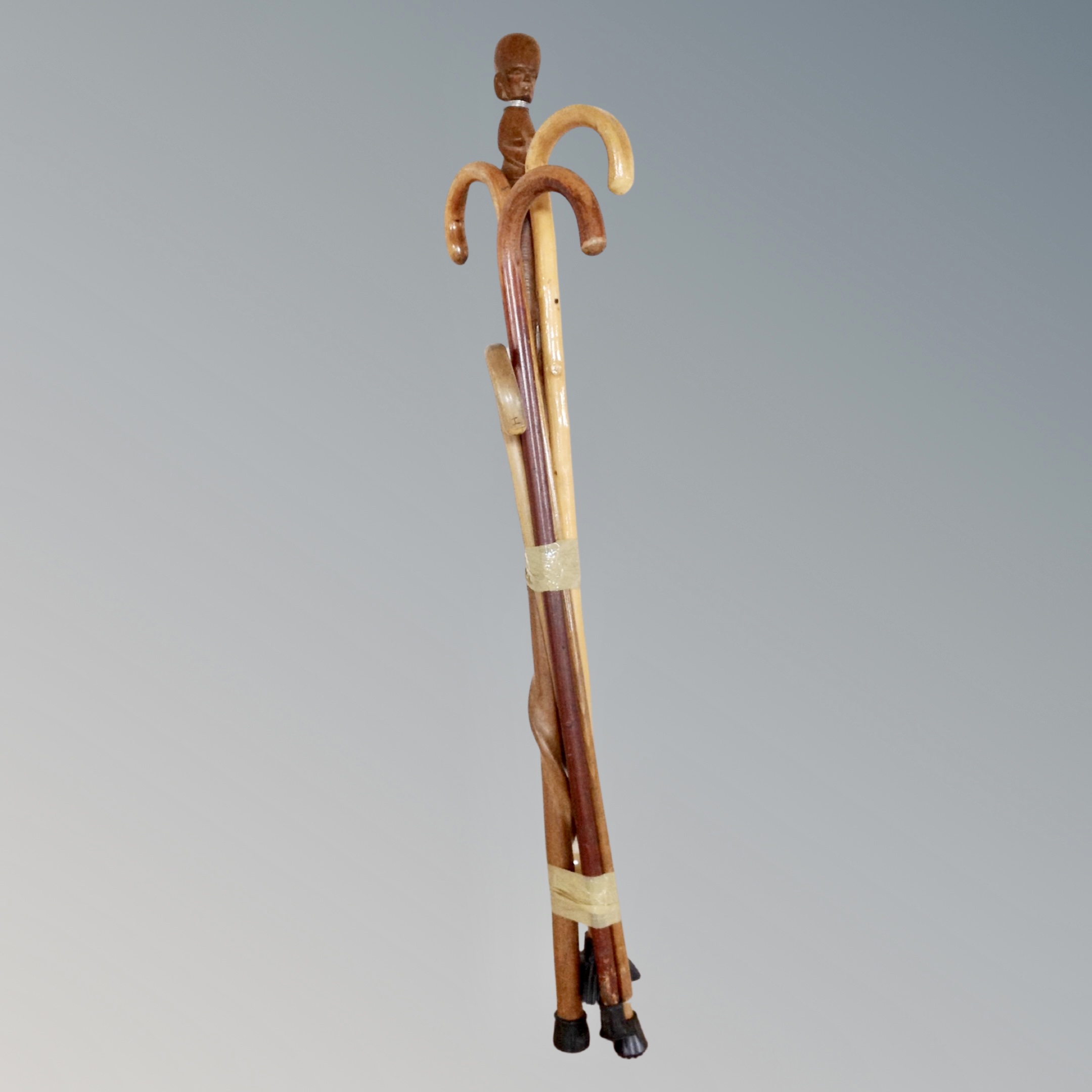 A bundle of five wooden walking sticks including a tribal example