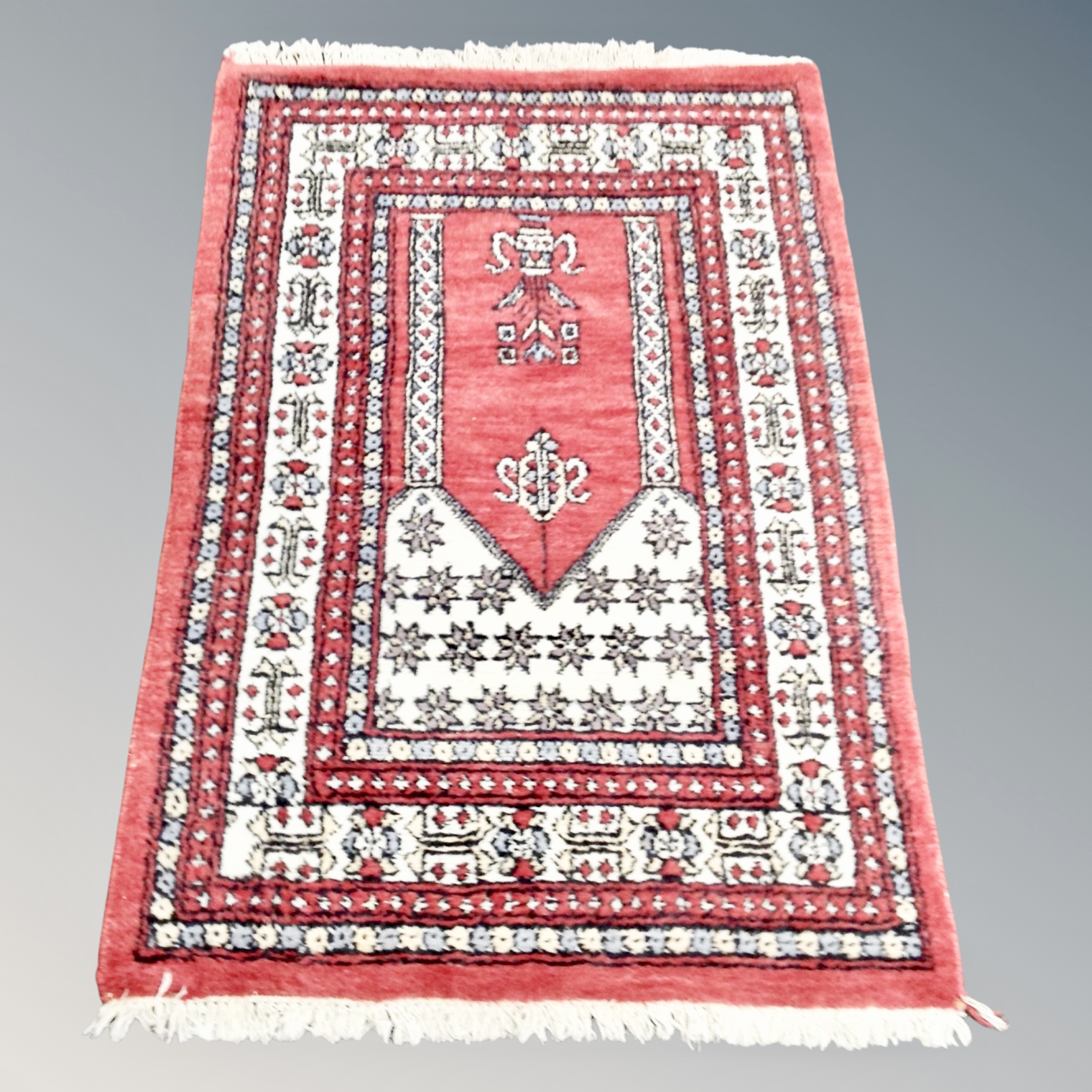 An Iranian prayer rug on red ground,