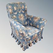 A 20th century armchair in blue floral fabric