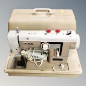 A Newhome electric sewing machine in case together with two rush seated stools