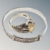 A decorative silver ring with inset stone and a child's silver bangle