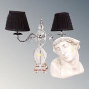 A contemporary bust together with a twin branch table lamp