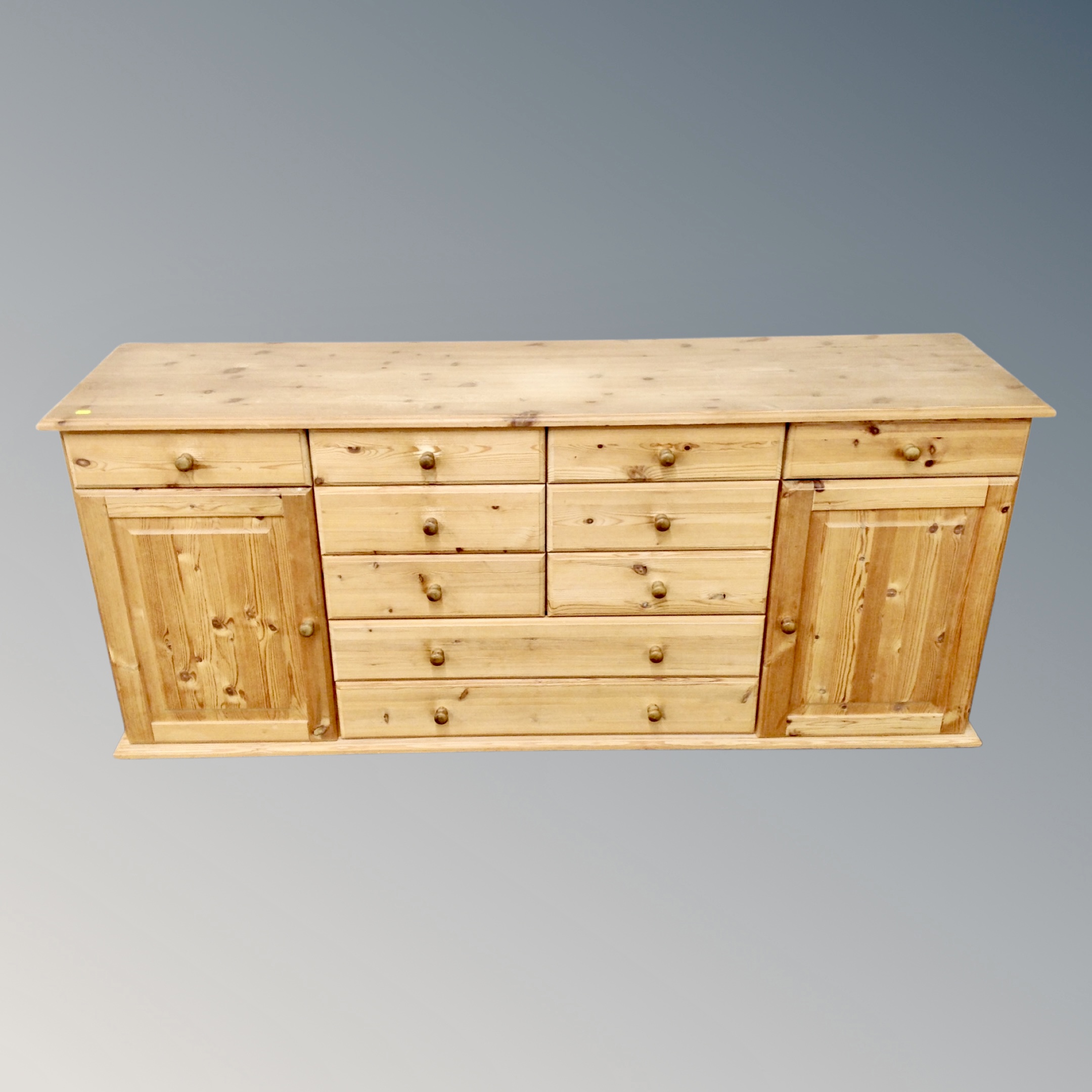 A pine sideboard fitted with cupboards and drawers,