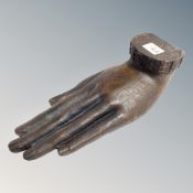 A cast resin hand decorated with a relief portrait of Buddha