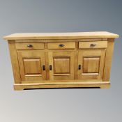 A contemporary solid oak sideboard fitted with drawers and cupboard,