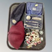 A tray of assorted costume jewellery, cased silver manicure set, Girl Guide hat,