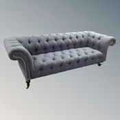 A Chesterfield settee in studded blue upholstery,