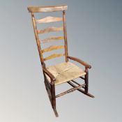 A beech and rattan ladder backed rocking chair