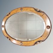 An Edwardian oak framed oval mirror,