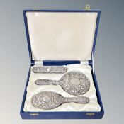 A three piece silver backed dressing table set in fitted case