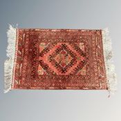 An Afghan rug of geometric design, on red ground,