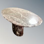 A faux marble oval shaped pedestal dining table,
