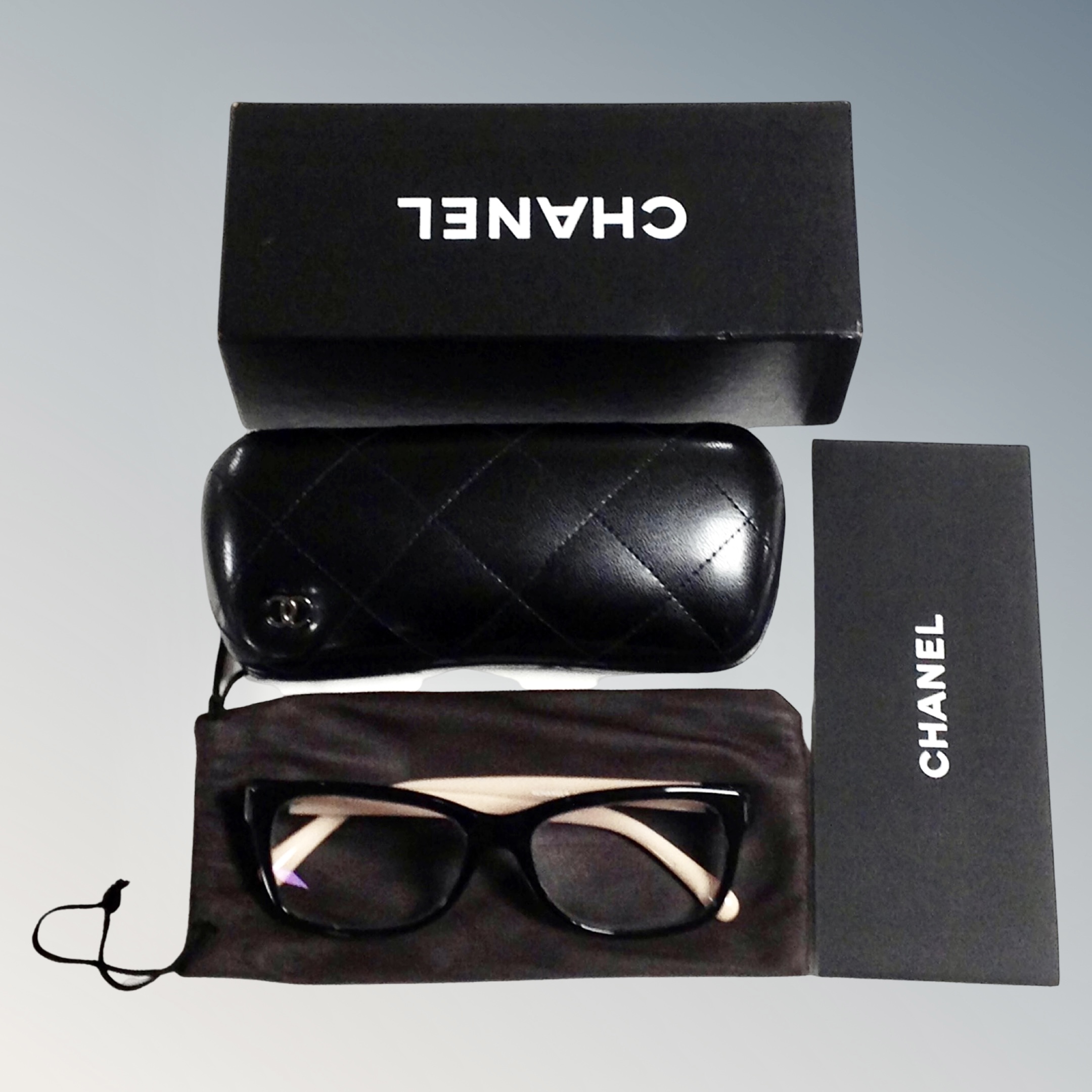 A pair of lady's Chanel prescription reading glasses in protective bag and box