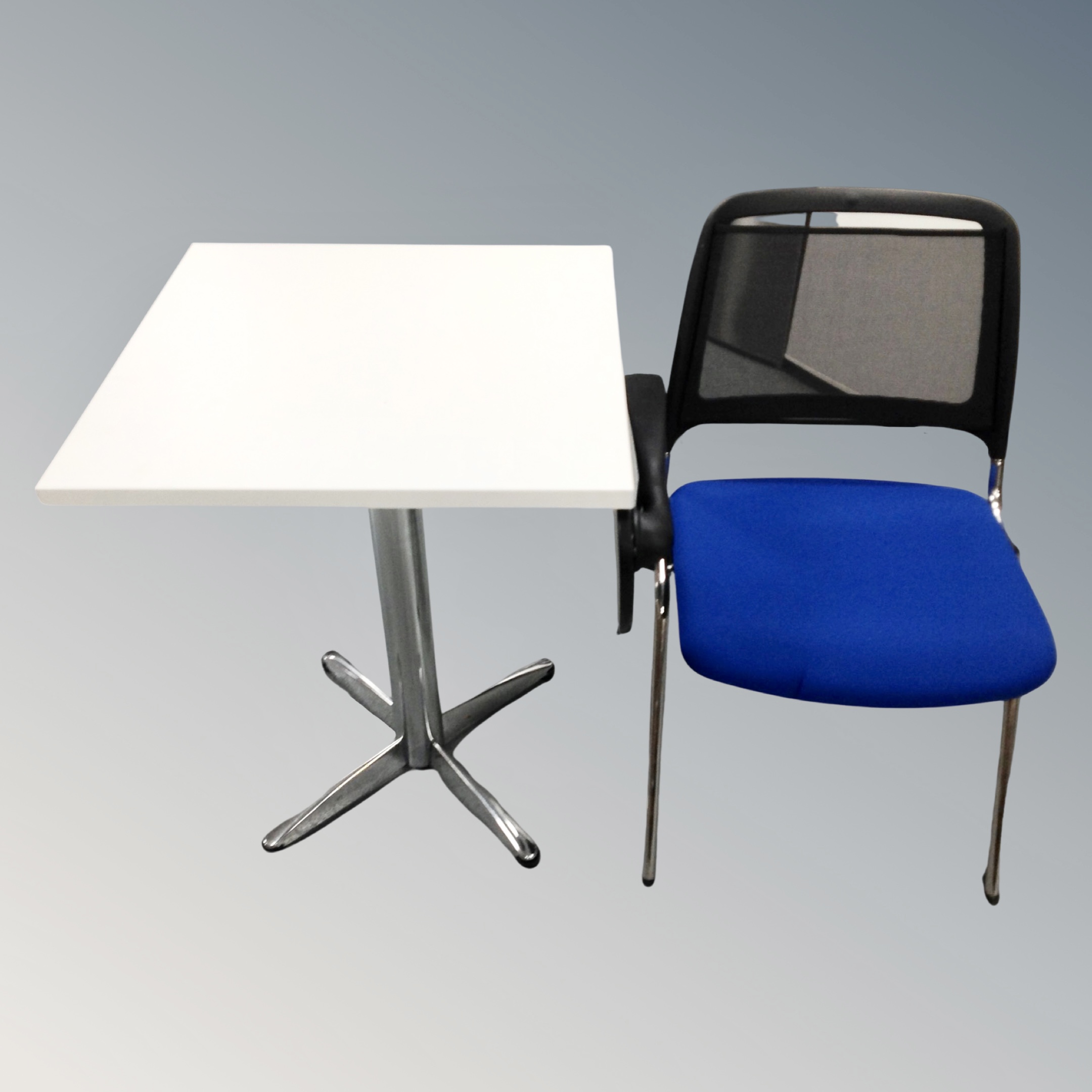 A white pedestal table together with a mesh back and fabric study chair with adjustable tray