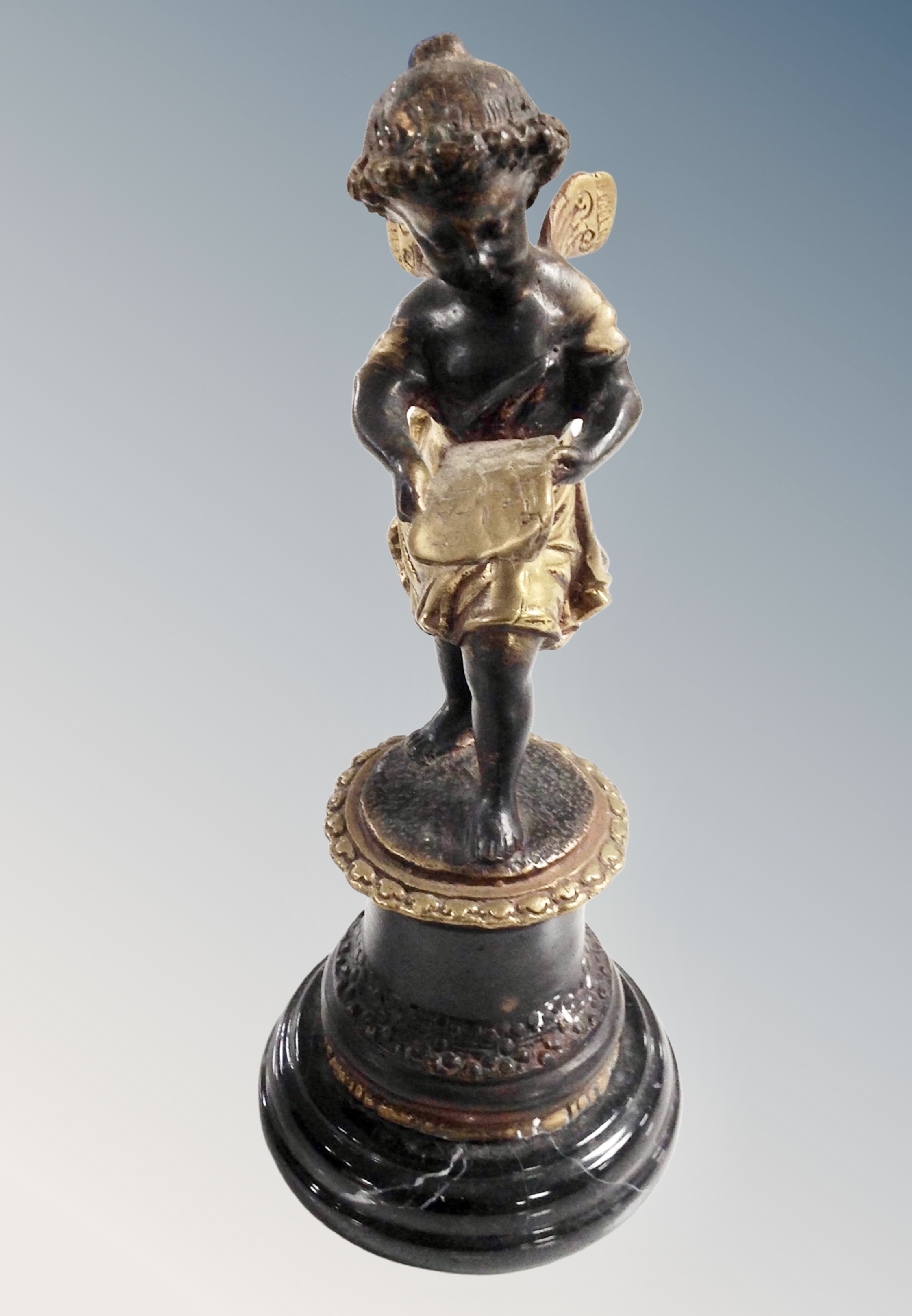 A patinated brass figure of an angel on polished socle,