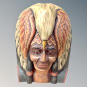 A carved wooden bust of a Native American with eagle head dress,