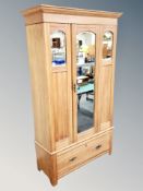 An Edwardian pine mirror door wardrobe,