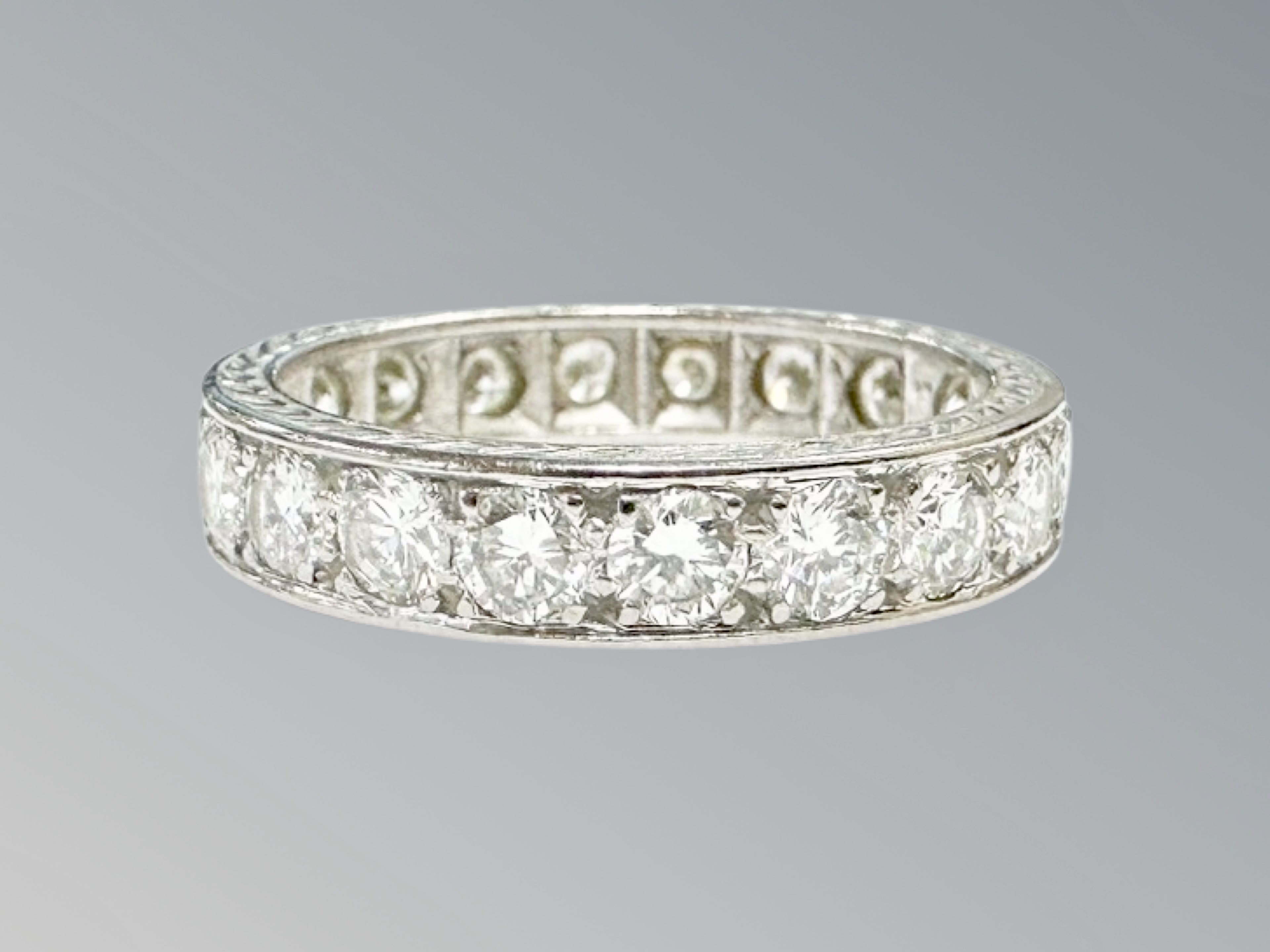 A platinum diamond eternity ring, channel set with twenty brilliant-cut stones,