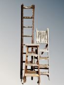 Two wooden step ladders and a further wooden ladder