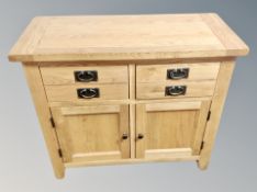 A contemporary light oak sideboard fitted with four drawers,