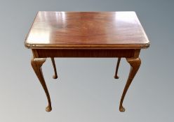 A reproduction mahogany turnover top tea table,