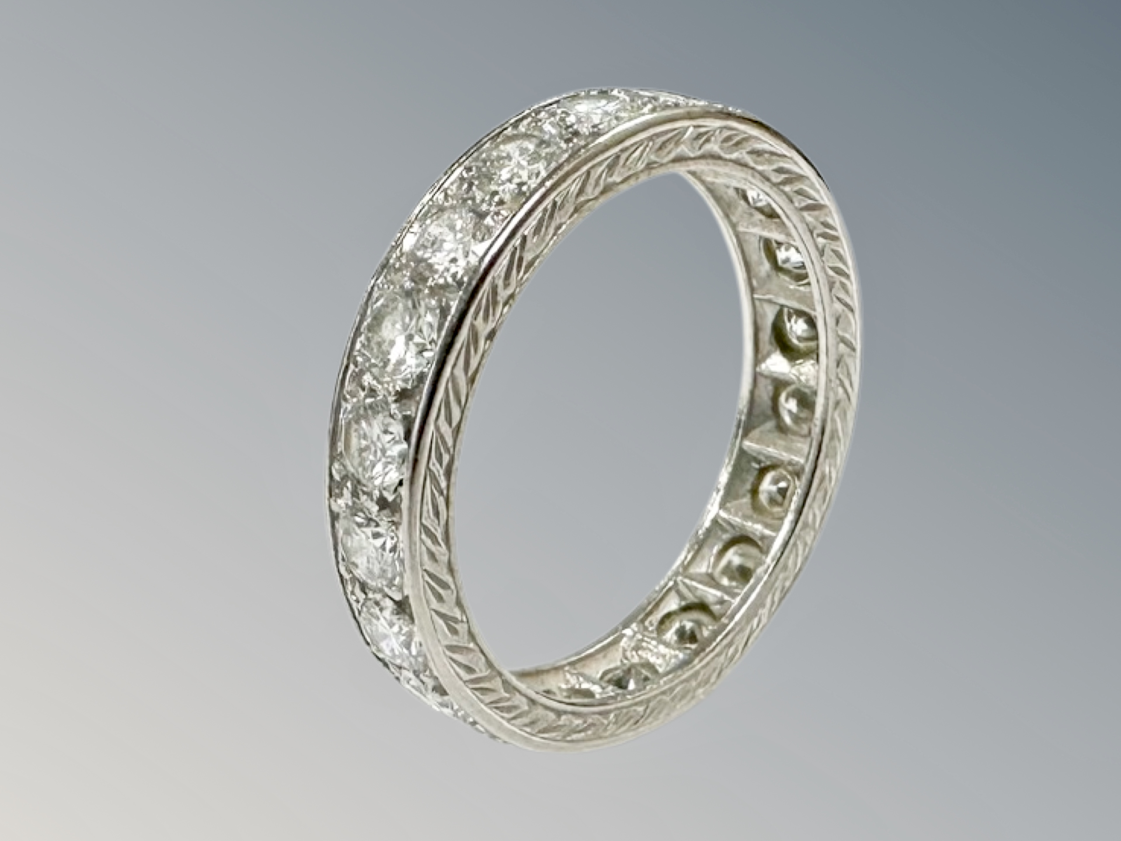 A platinum diamond eternity ring, channel set with twenty brilliant-cut stones, - Image 2 of 2
