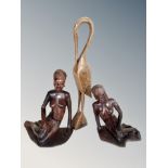 Two African carved wooden figures of seated ladies and a further figure of a stork,