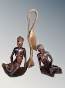 Two African carved wooden figures of seated ladies and a further figure of a stork,