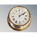 A circular brass ship's style clock,