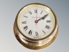 A circular brass ship's style clock,