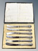 A cased set of six silver-handled butter knives.
