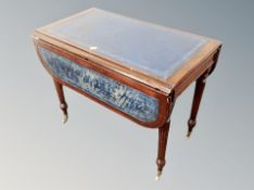 A reproduction Regency style flap sided table with tooled leather top,