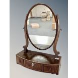 An early 19th century inlaid mahogany oval toilet mirror