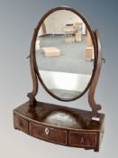 An early 19th century inlaid mahogany oval toilet mirror