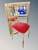 A brass finished metal bedroom chair together with a decorative mirror