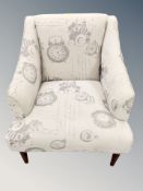 A contemporary upholstered armchair in 'clock' motif fabric
