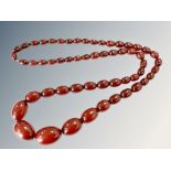 A cherry amber bead necklace, the graduated oval beads ranging from 1cm to 2.