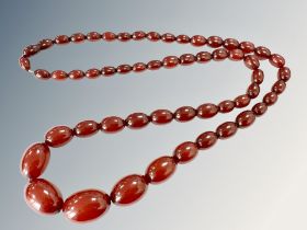 A cherry amber bead necklace, the graduated oval beads ranging from 1cm to 2.