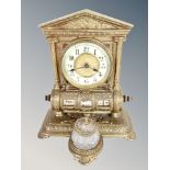 An ornate cast brass desk clock/calendar with crystal inkwell,