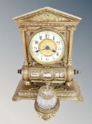 An ornate cast brass desk clock/calendar with crystal inkwell,
